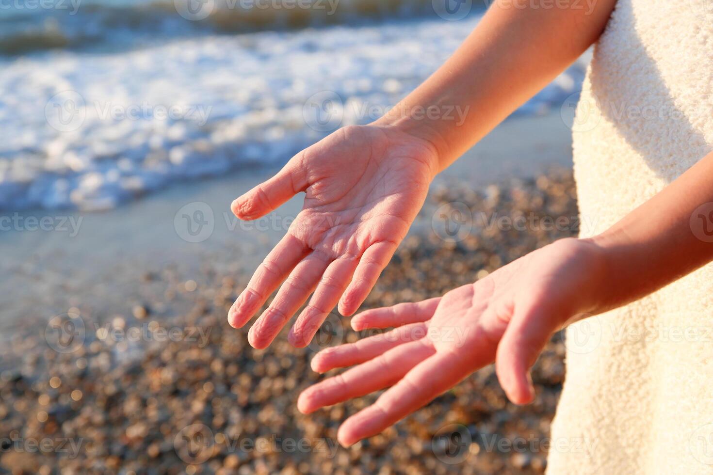 Wrinkled fingers from the water, after a long stay at sea. A child on the seashore. photo