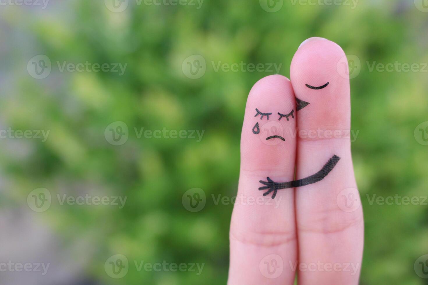 Fingers art of displeased couple. Woman cries, man reassures her. He kisses and hugs her. photo