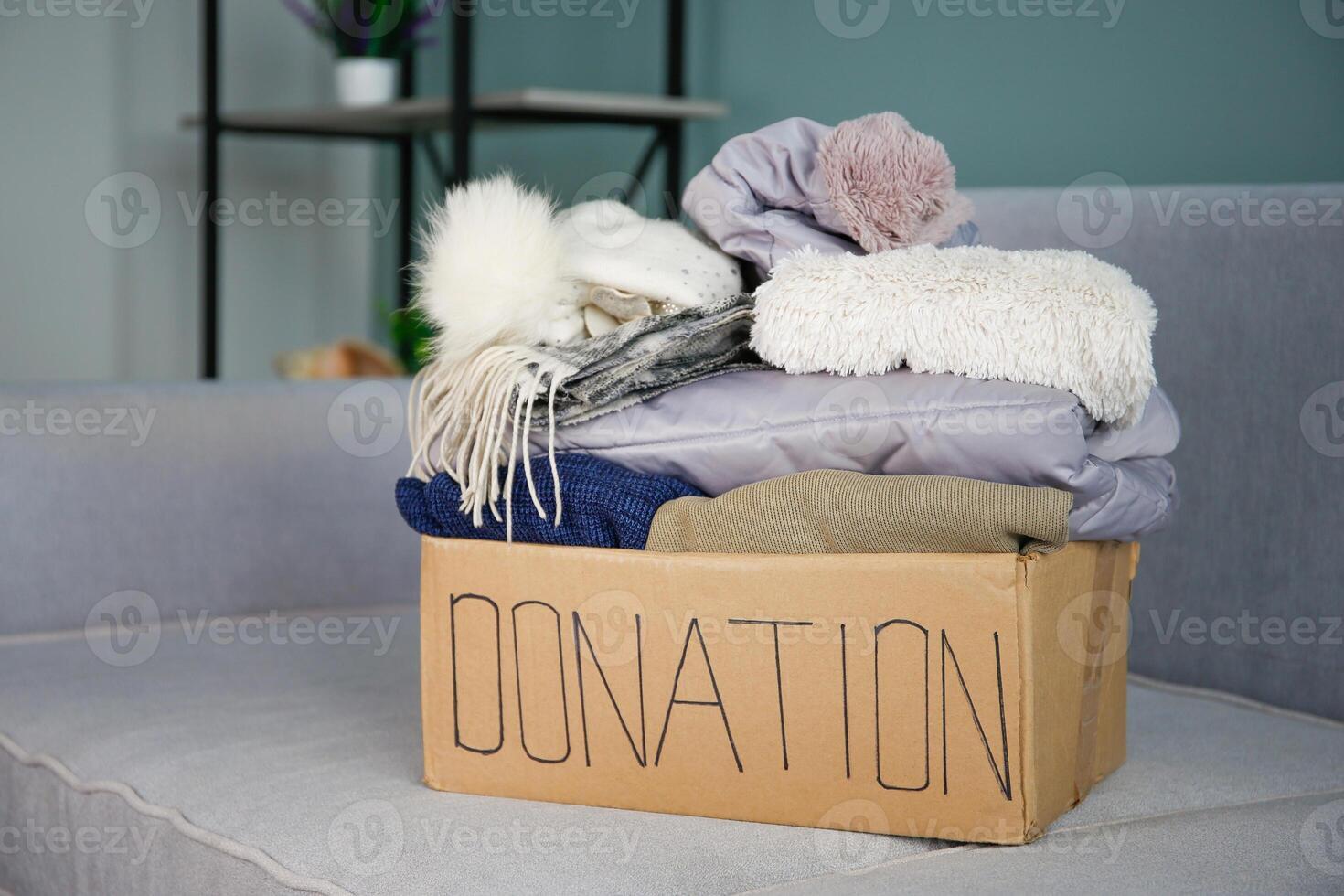 Donation box with clothes on the sofa in the living room. photo
