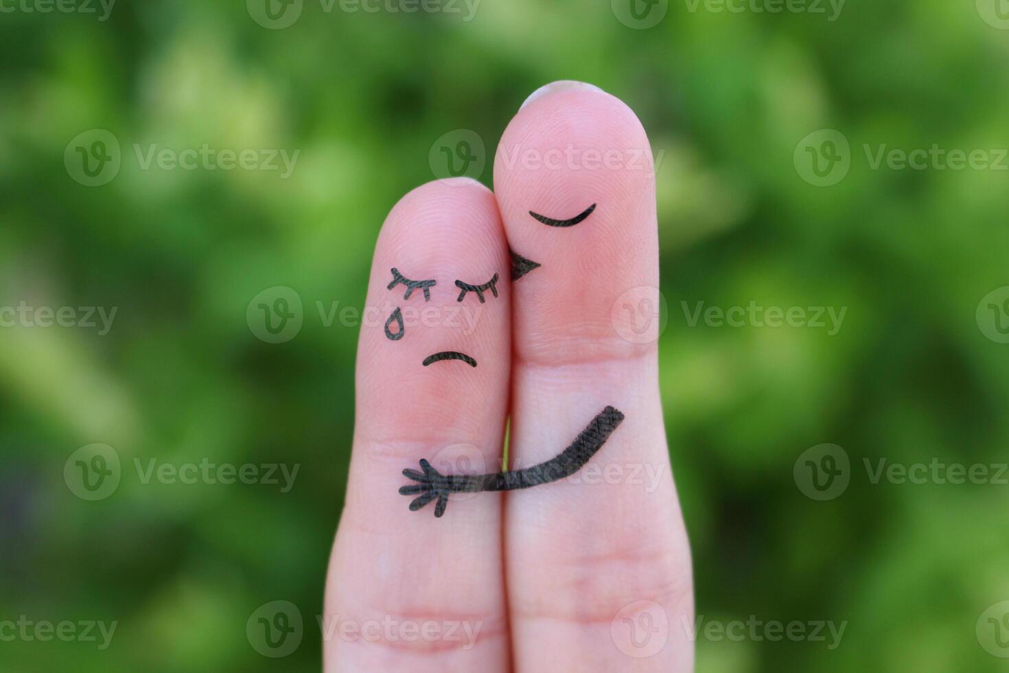 Finger art of displeased couple. Woman cries, man reassures her. He kisses and hugs her. photo