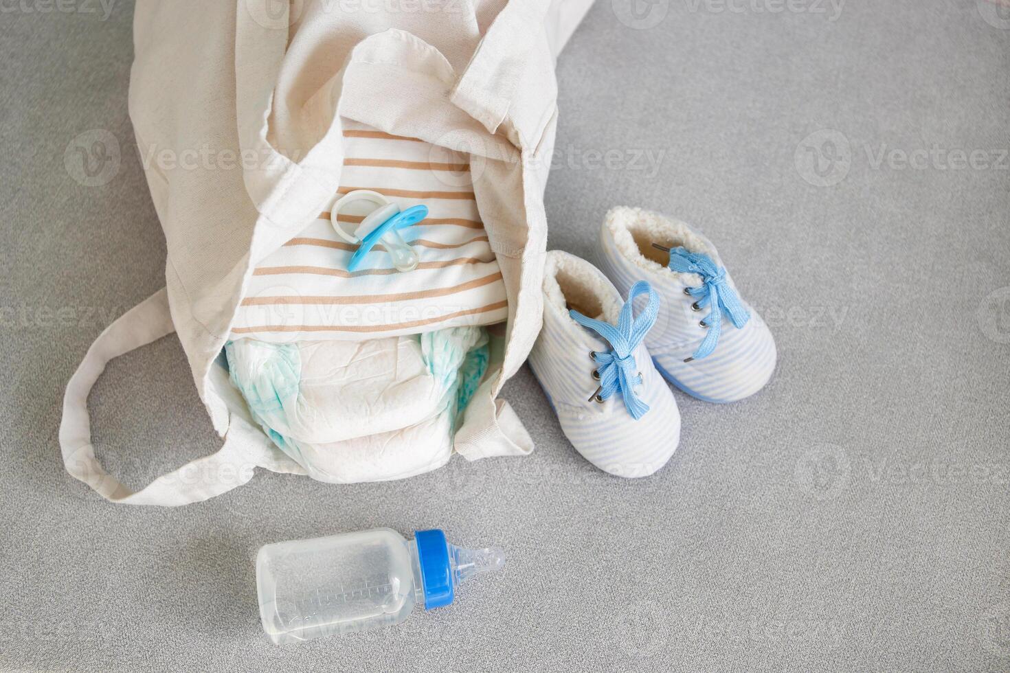 A bag for mom with newborn's belongings on a gray sofa. photo