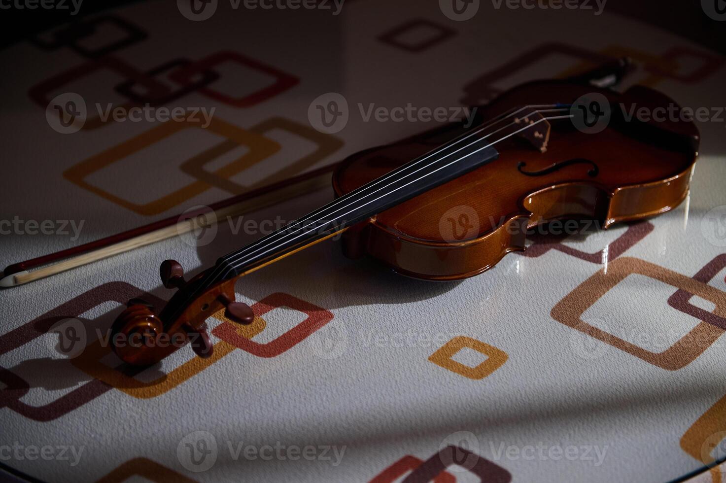 Elegant violin resting on a patterned table in soft light photo
