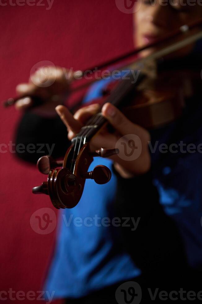 Close-up of musician playing violin with focus on strings photo