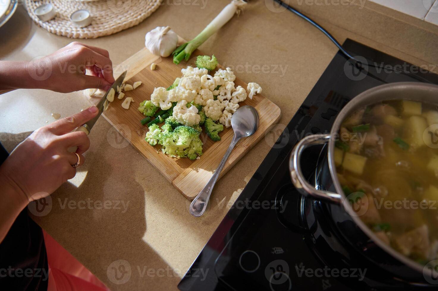 Person preparing fresh vegetables for a healthy homemade soup photo