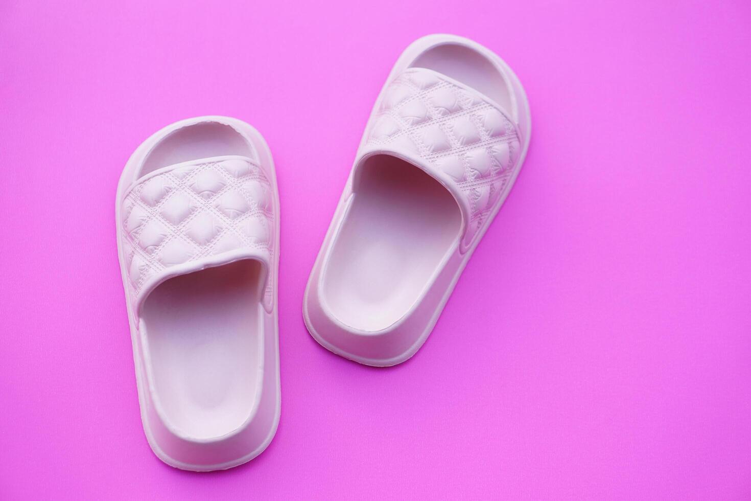 Pairs of pink rubber slippers, shoes for easy day wearing and walking, isolated on pink background. concept, fashion shoes , light and comfortable. photo