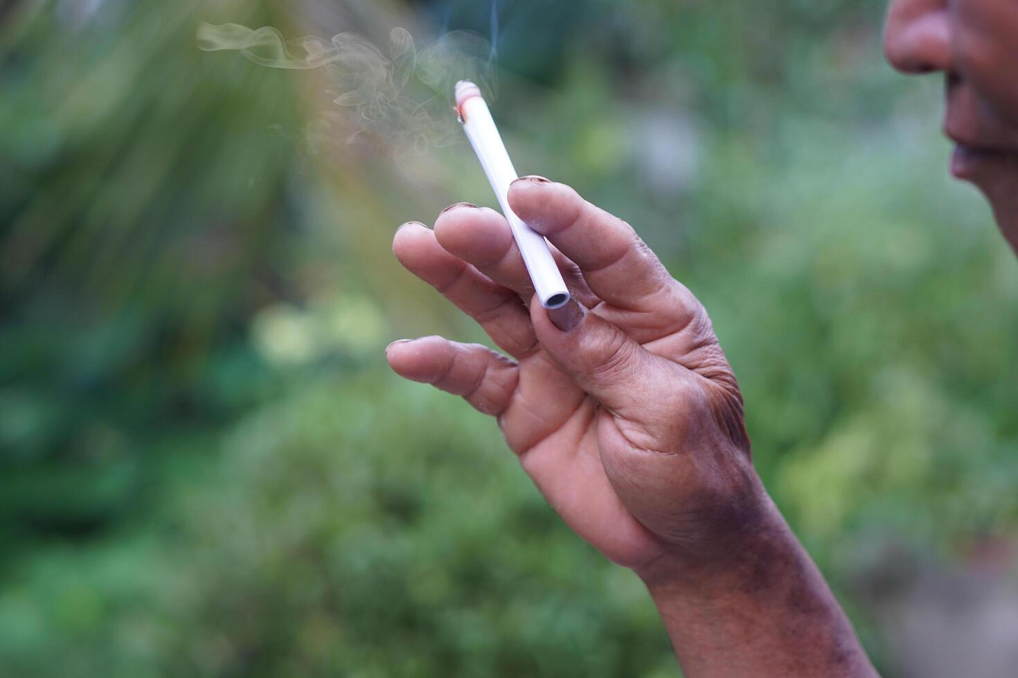 Close up man is smoking cigarette. Concept, smoking is bad for health. Private favorite for relaxation but can cause health problems respiratory disease and addict. photo