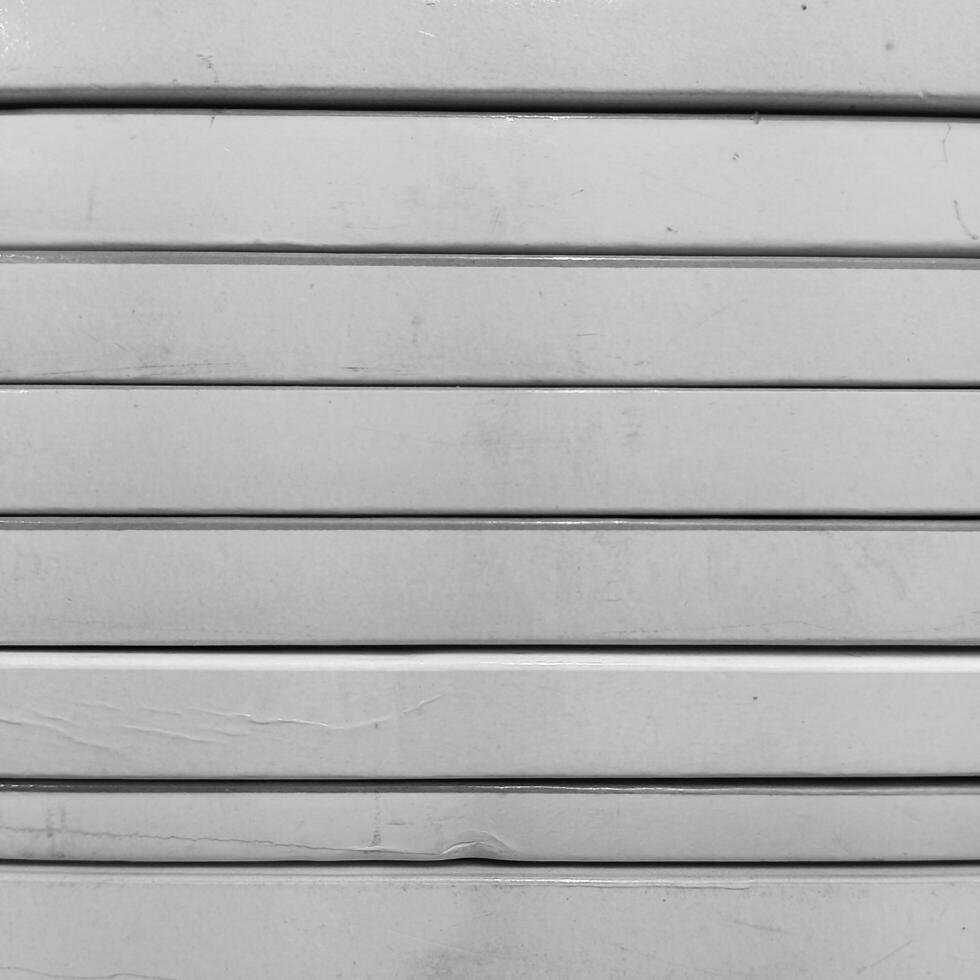 A black and white photo of a wall with a row of white doors