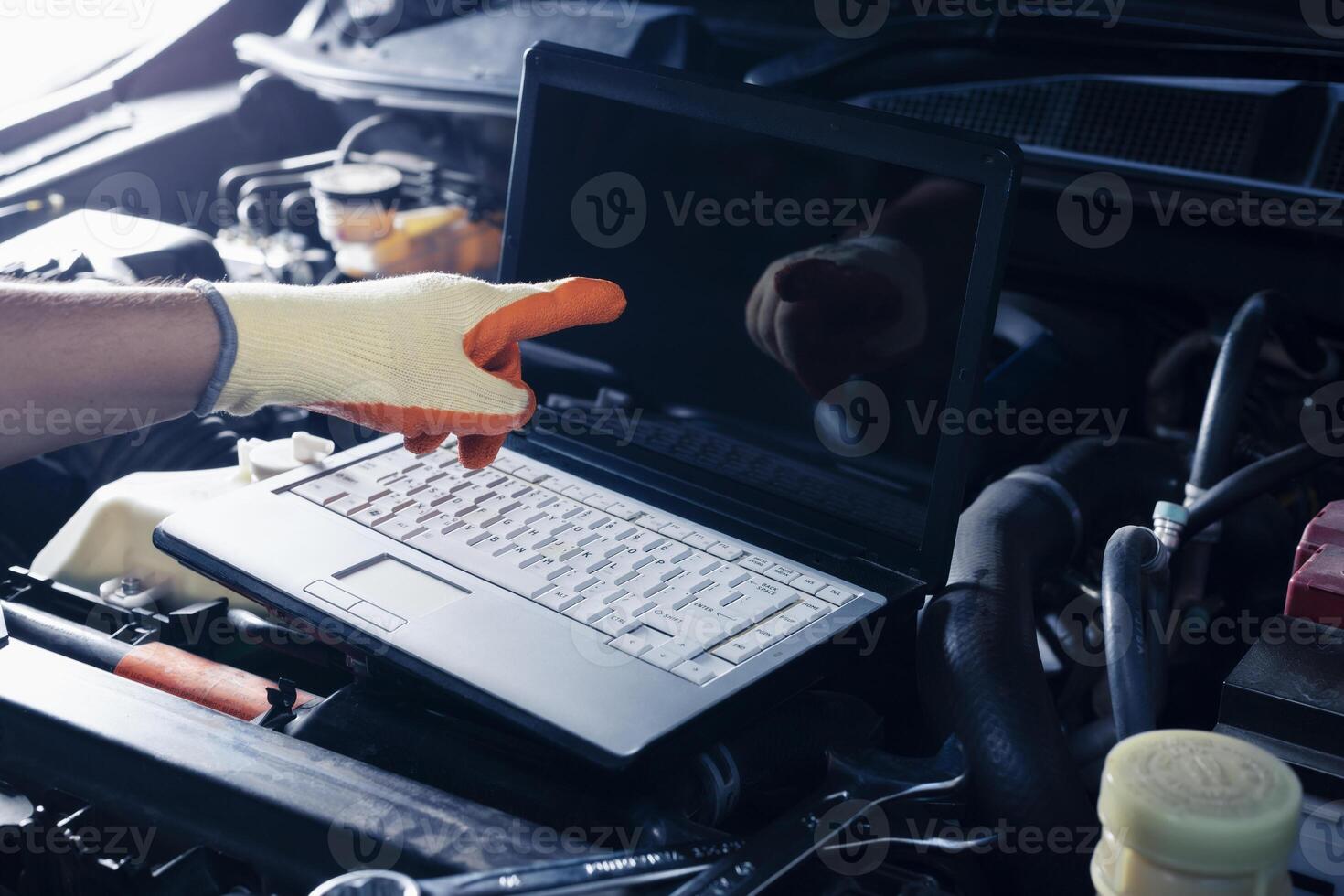 Car inspection service using a modern computer system. and a modern mechanic in the garage Auto mechanics use computer software to check two engines are running and repair them. photo