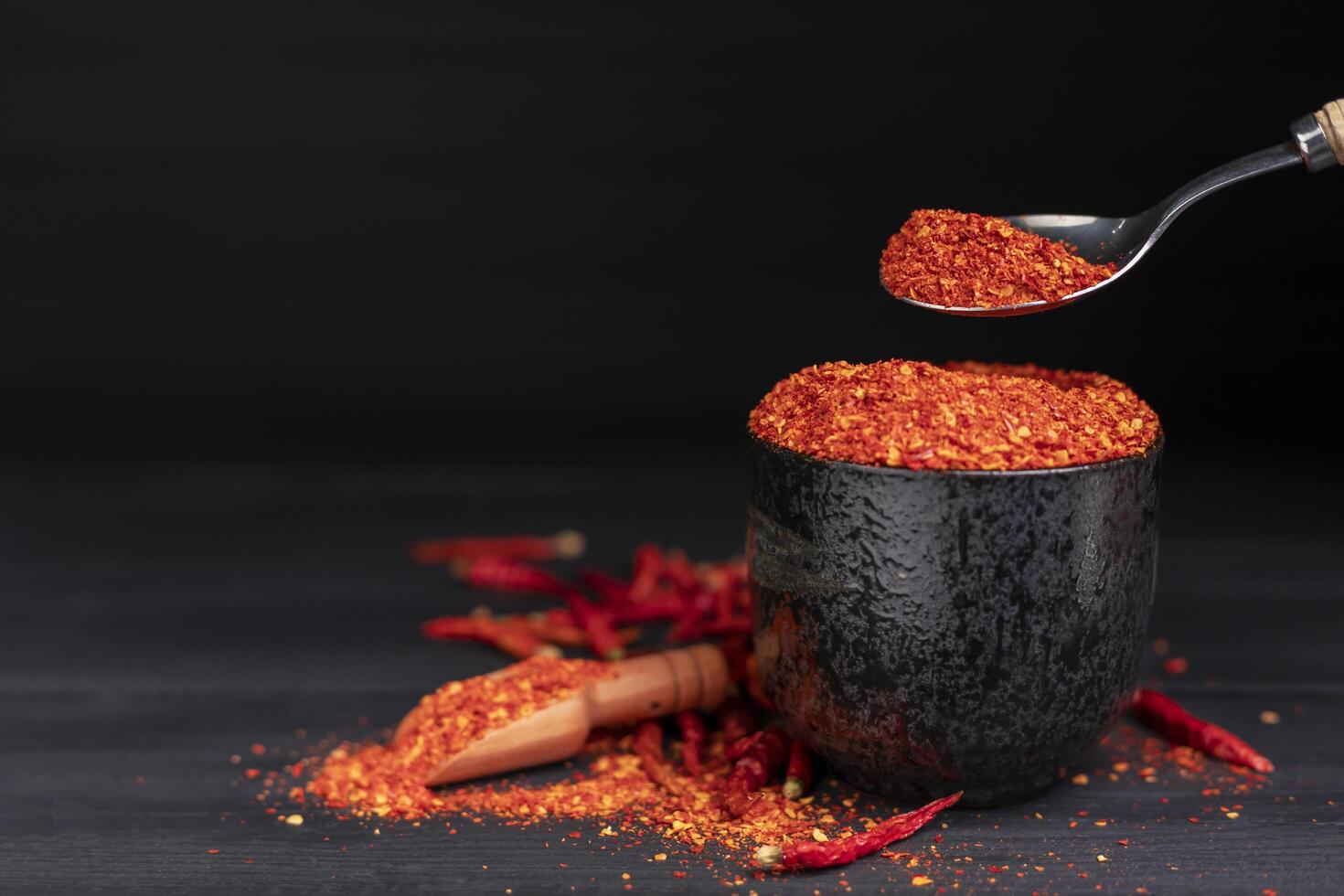 Paprika, red chili powder, dried chilies, spicy seasoning. On the dark wooden floor Focus on a specific point photo