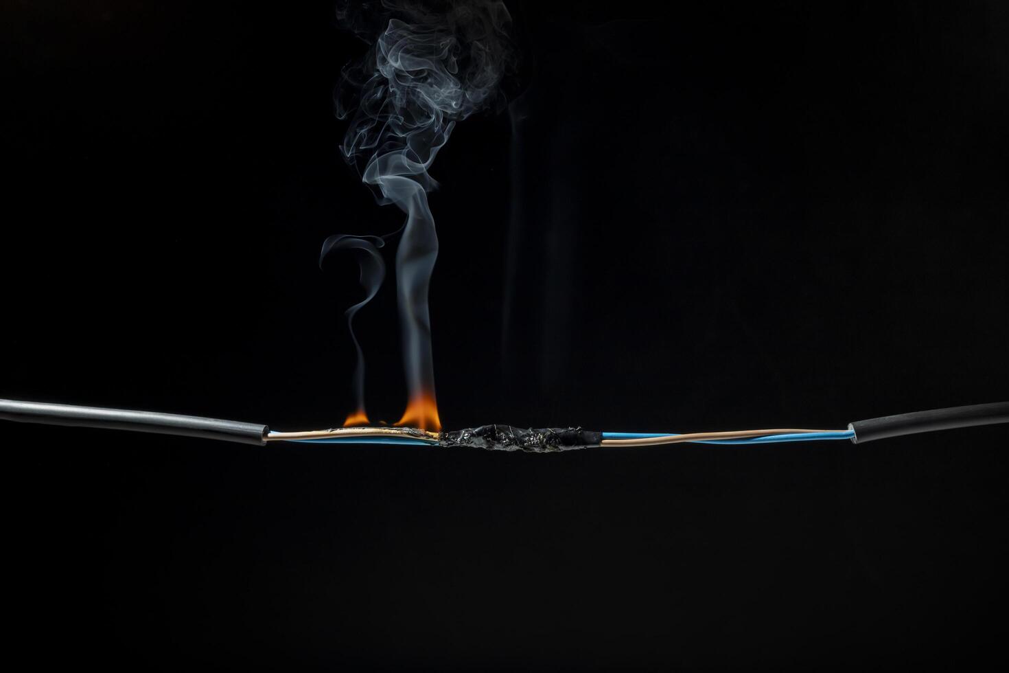 Flames from electric shocks Short-circuited cables cause sparks, explosions, excessive power usage, damaged and non-standard equipment. on a dark black background photo