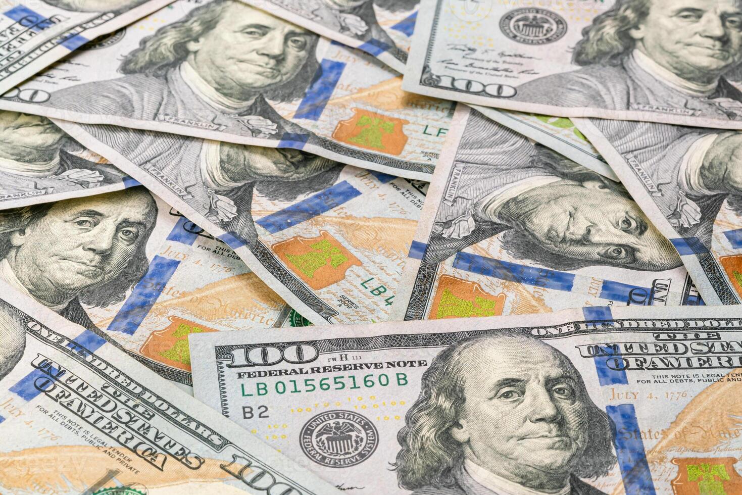 Closeup view pile of several one hundred U.S. dollars banknotes on a table. Concept for business and savings. photo