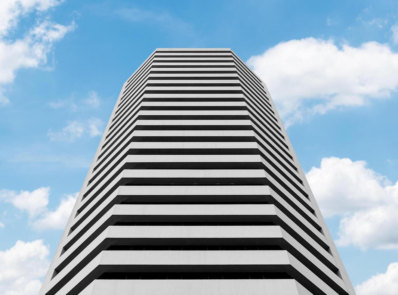 Bottom up view white office building with blue sky background photo