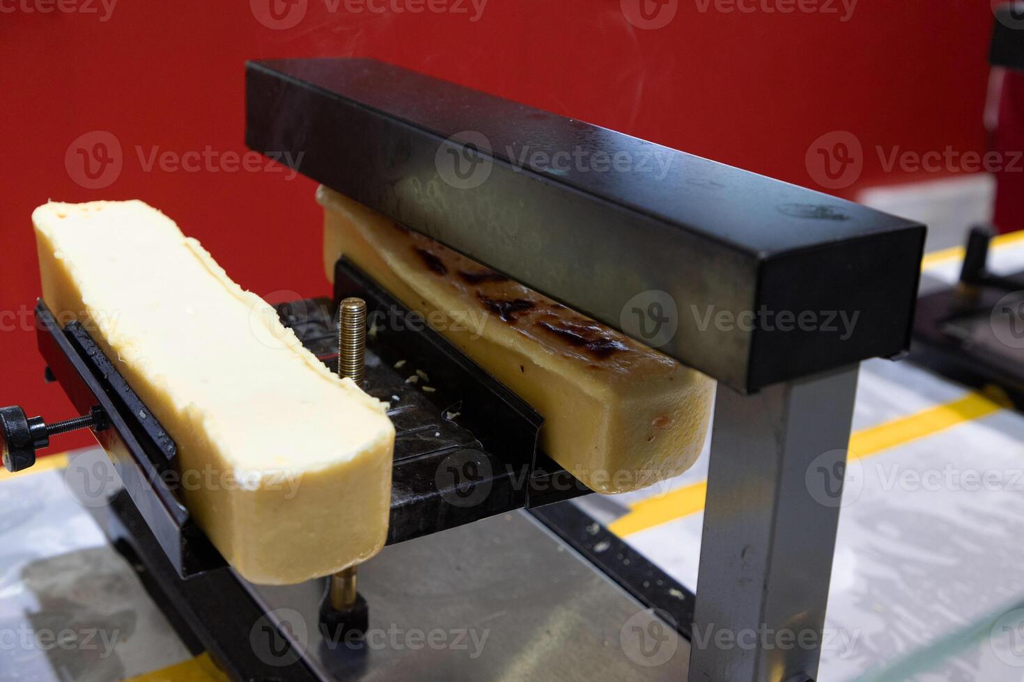 delicious wheel of raclette cheese has been heated on cutting edge. photo