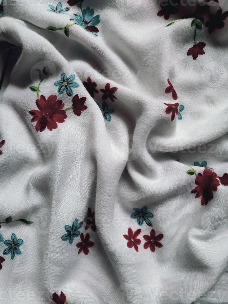 The basic fabric is white with red and blue floral motifs and leaves photo