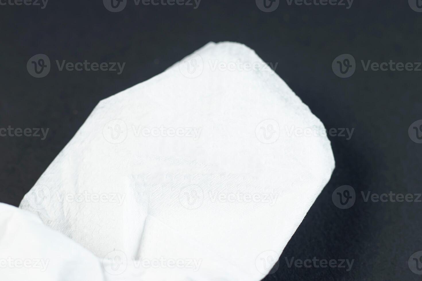 Folded White Napkin or tissue paper isolated on black background side view of a formal dining table setting photo