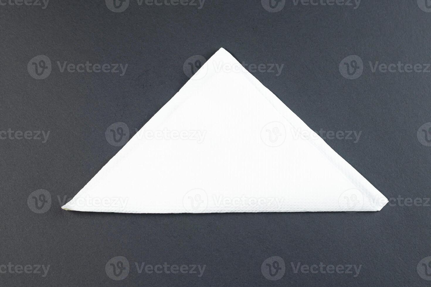 Folded White Napkin or tissue paper isolated on black background top view of a formal dining table setting photo