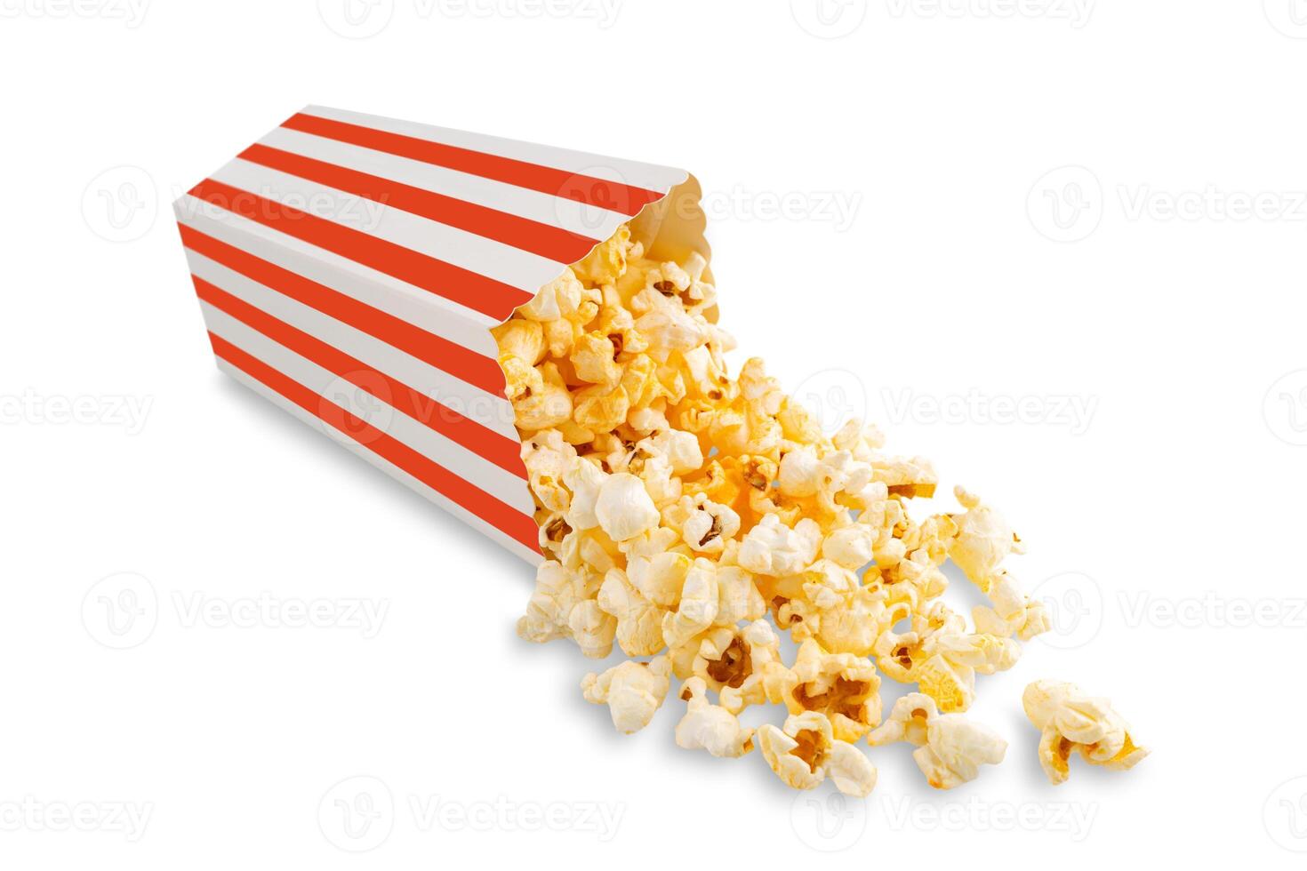 Tasty cheese popcorn falling out of a red striped carton bucket, isolated on white background photo