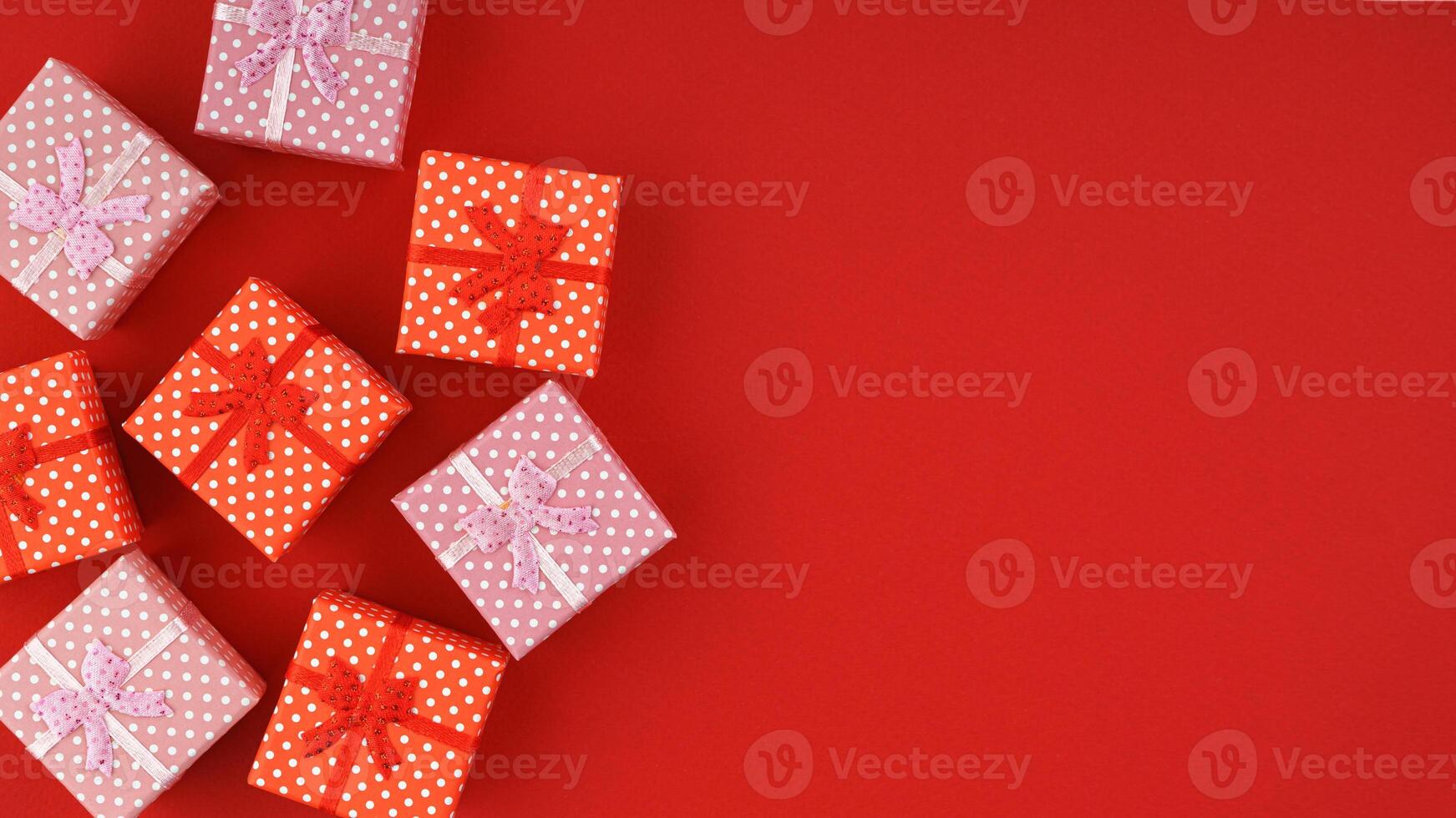 Red and pink gift boxes on red background with copy space. photo