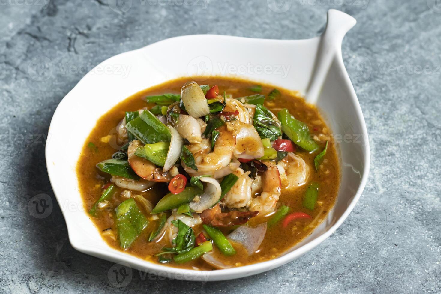 Prawn Chili Paste curry including capsicum, onion and red pepper served in bowl isolated on grey background side view of thai food photo