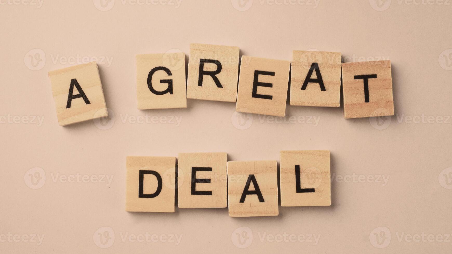 Word of A Great Deal. Text written by wood toy or wood cubes on white paper background photo