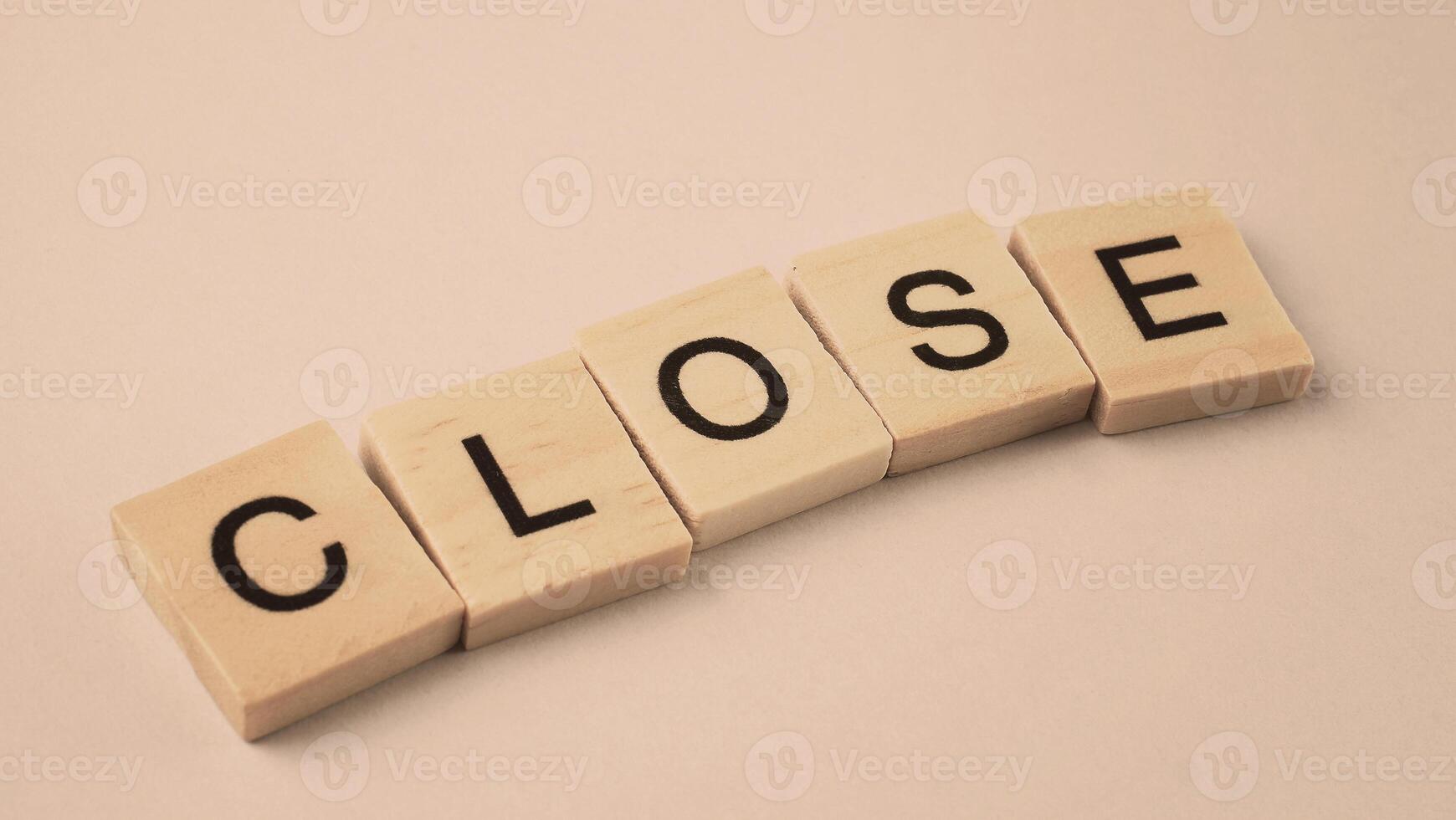 Word of Close. Text written by wood toy or wood cubes on white paper background photo