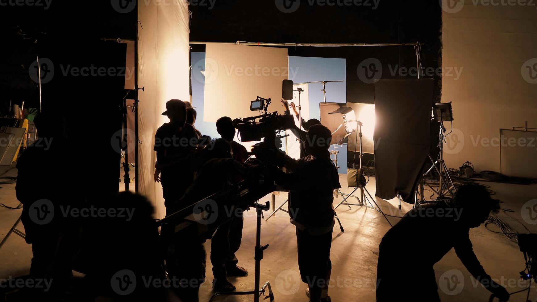 Silhouette of film crews and camera on special dolly crane with film lights and set. photo