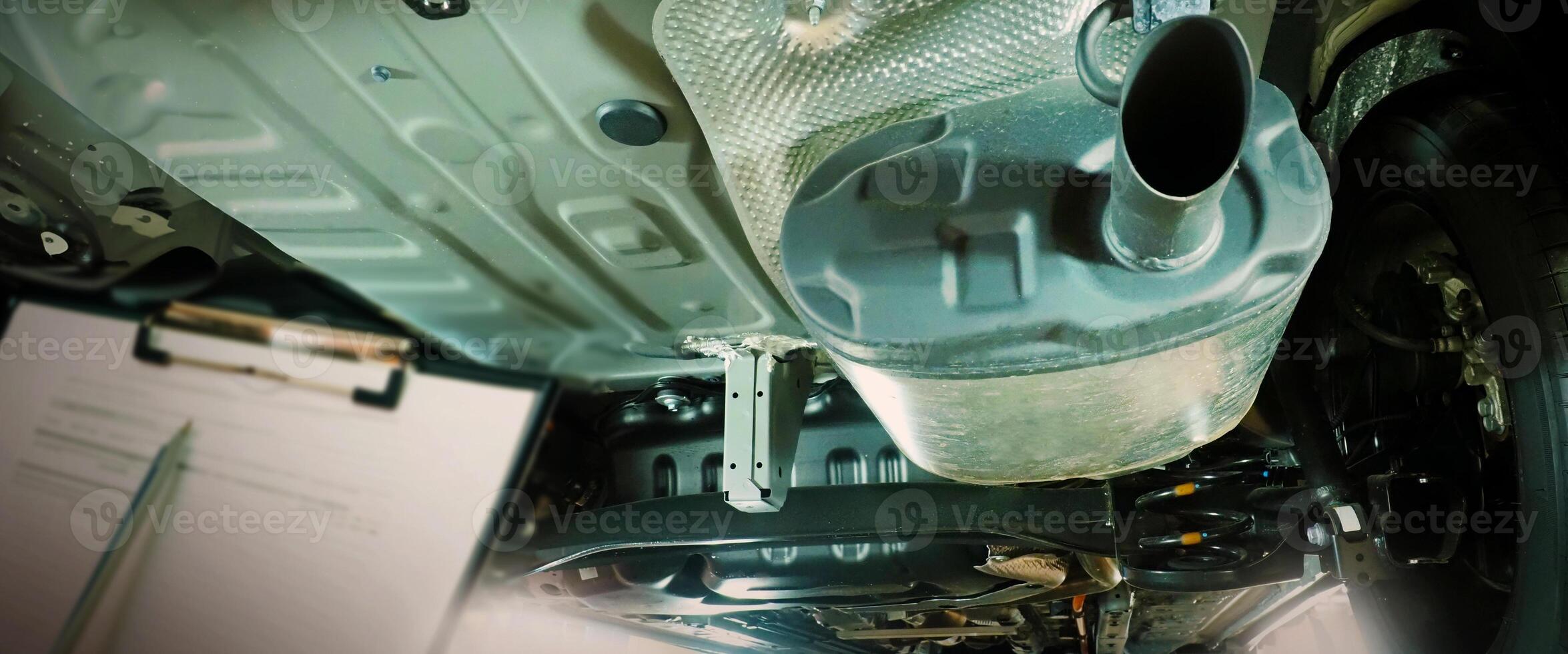 Under car exhaust pipe and suspension. Automotive mufflers. Inspection of car for Defects. Metal fittings and pipes for the muffler. Suspension elements and exhaust system. Auto parts and car service photo