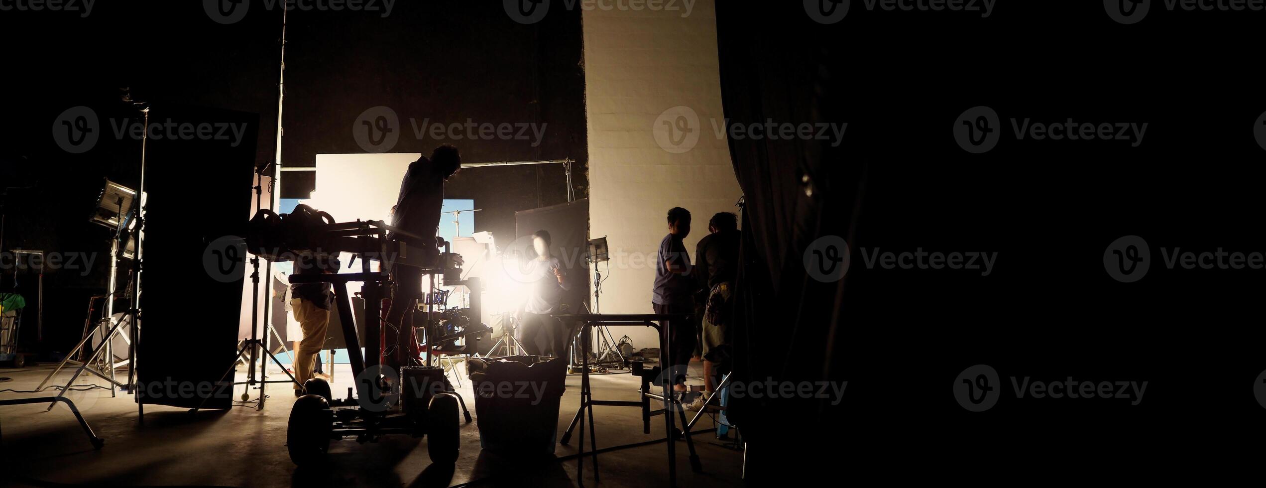Silhouette of film crews and camera on special dolly crane with film lights and set. photo