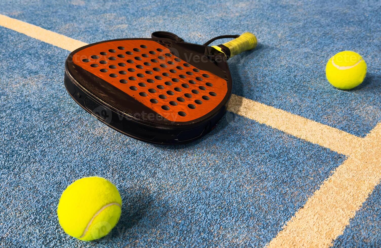 Black professional paddle tennis racket and ball with natural lighting on blue background. Horizontal sport theme poster, greeting cards, headers, website and app photo