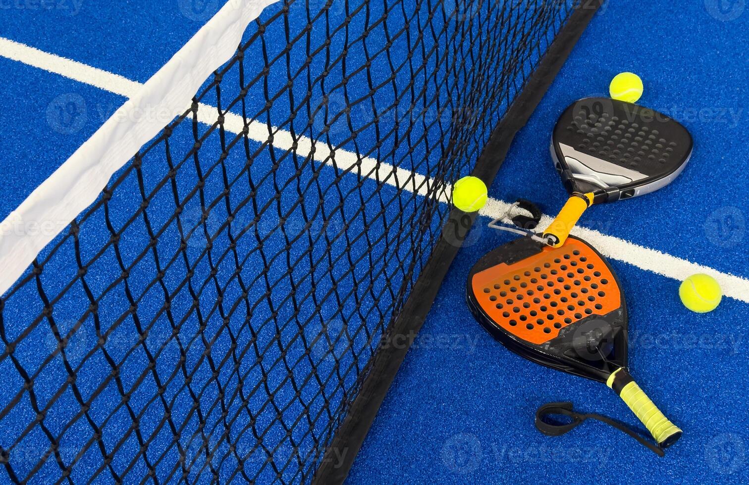 Black professional paddle tennis racket and ball with natural lighting on blue background. Horizontal sport theme poster, greeting cards, headers, website and app photo