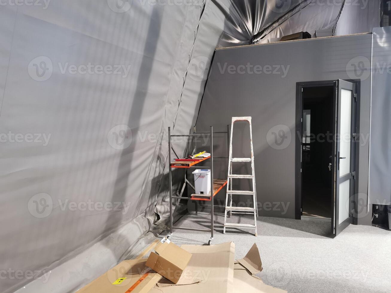 Photo of the apartment during the repair. Stepladder stands near the white wall.