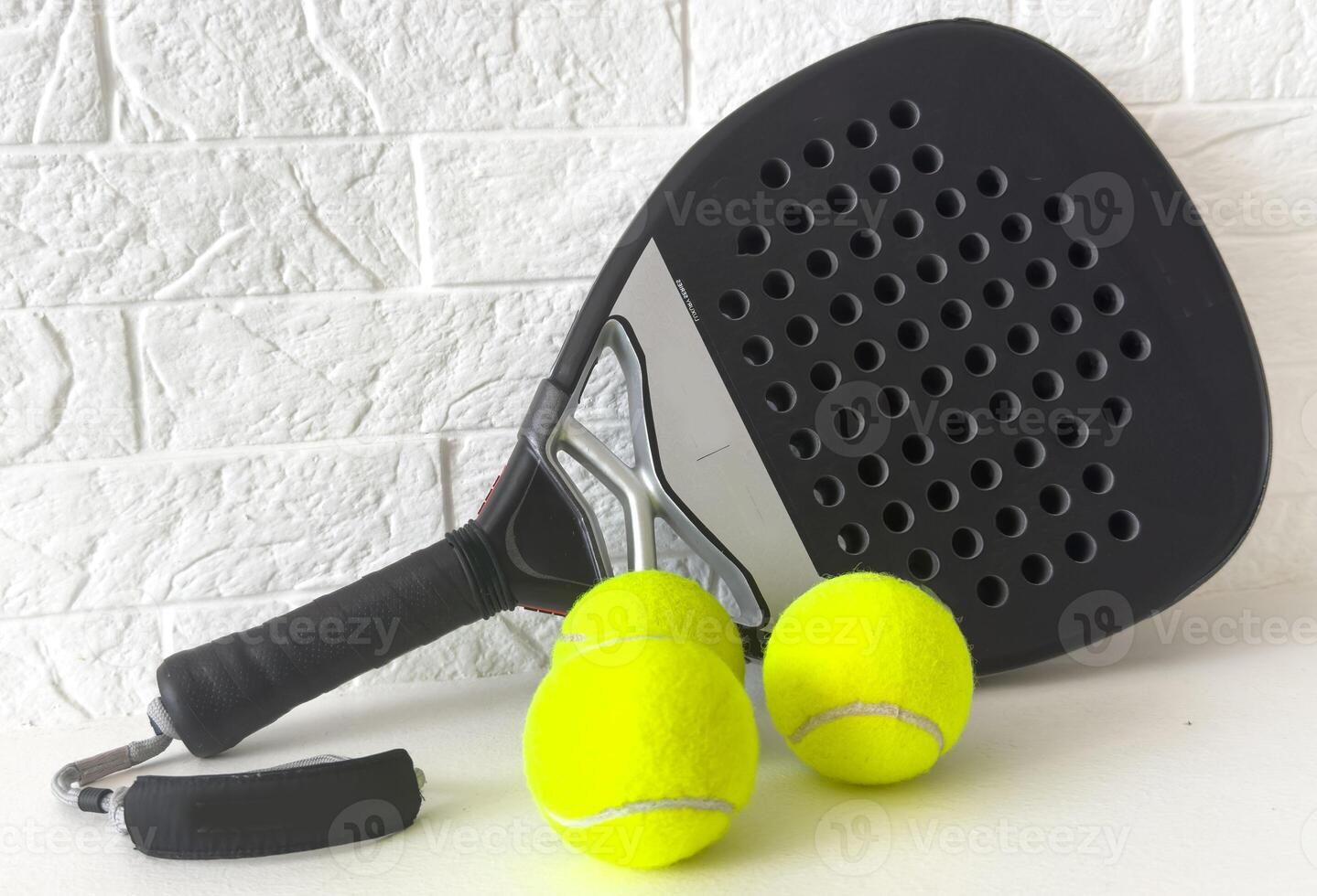 Set of paddle tennis rackets and balls on white table and white isolated background. Front view. photo