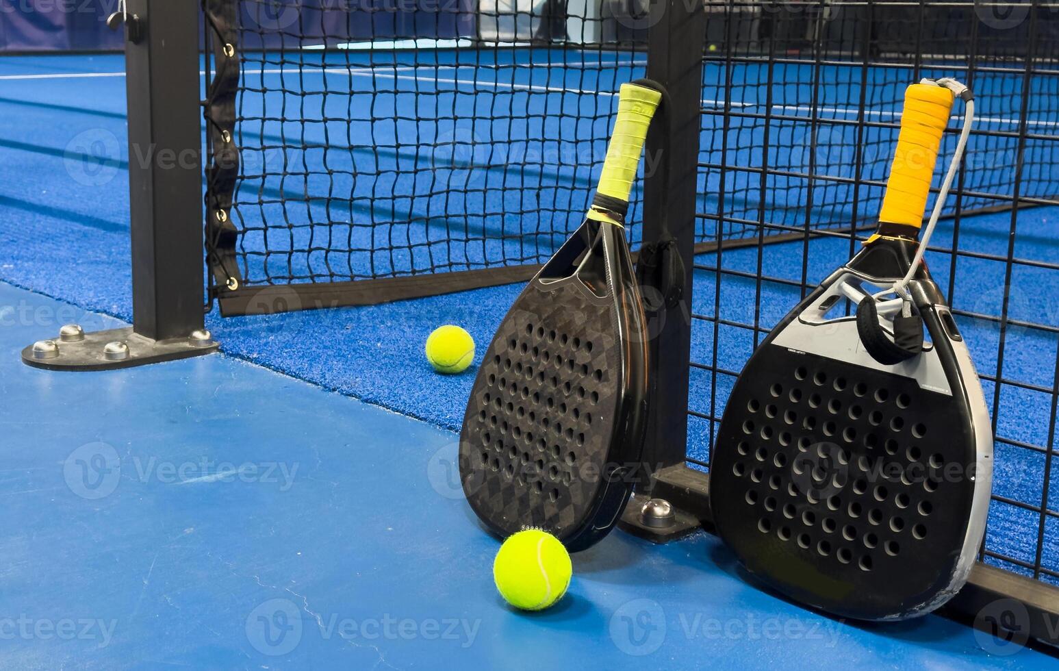 Black professional paddle tennis racket and ball with natural lighting on blue background. Horizontal sport theme poster, greeting cards, headers, website and app photo