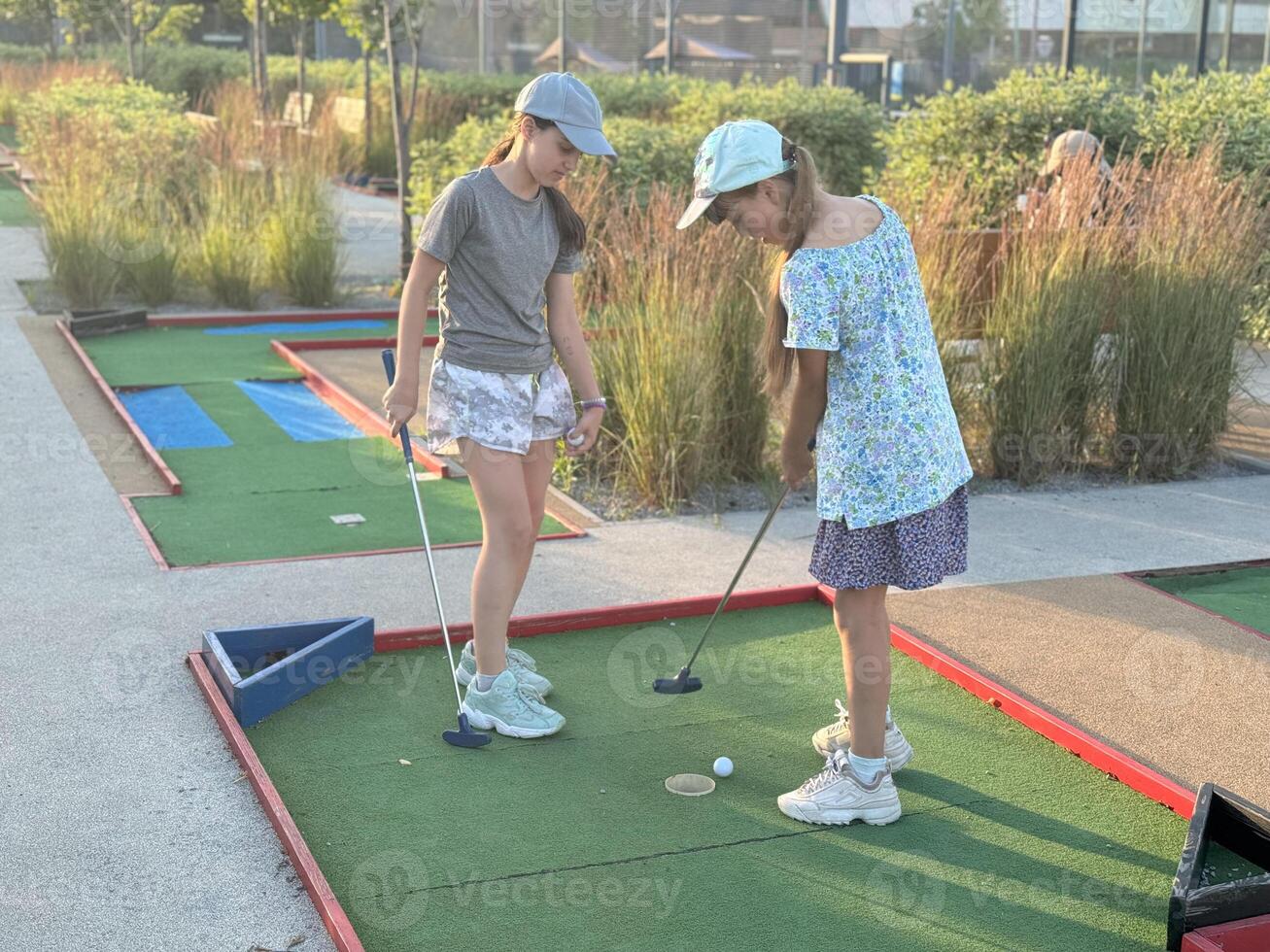 teenage girls play mini golf photo