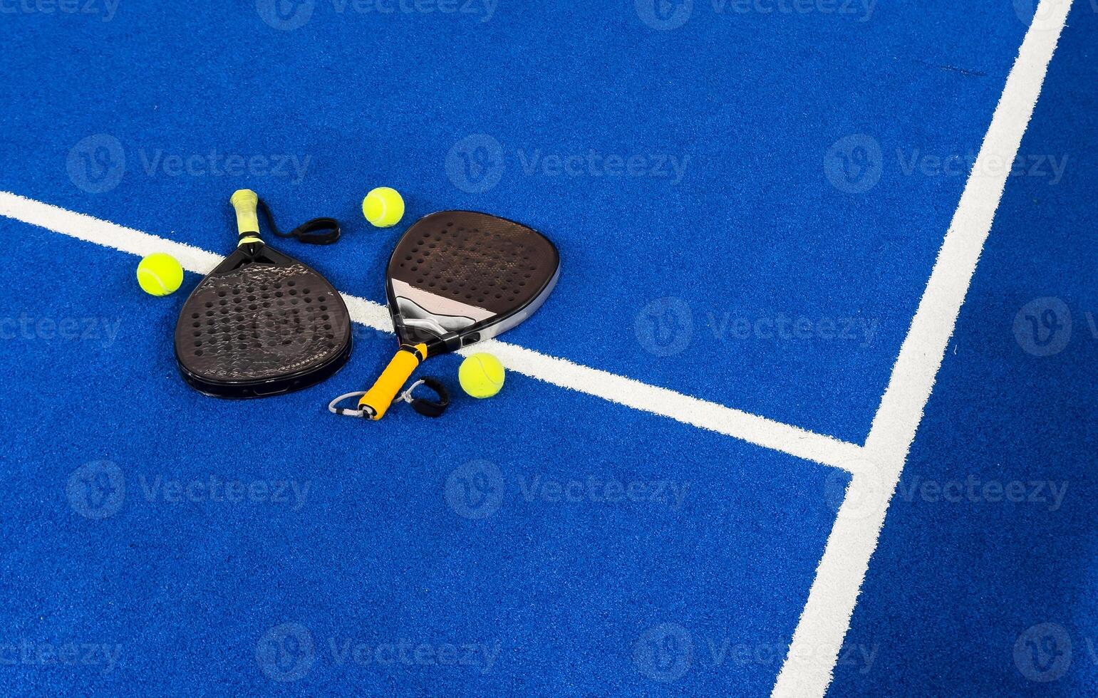 Black professional paddle tennis racket and ball with natural lighting on blue background. Horizontal sport theme poster, greeting cards, headers, website and app photo