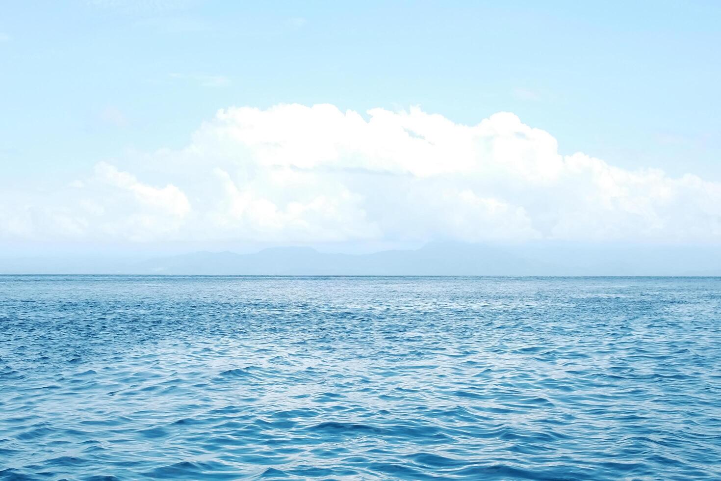 landscape of horizontal calm blue sea with wave and cloud and blue sky in bright day. Travel destination summer of ocean in Bali, Indonesia photo