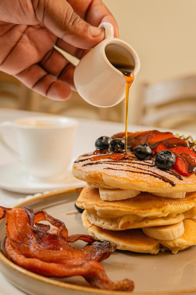Fruit crepes with chocolate and maple syrup for breakfast photo
