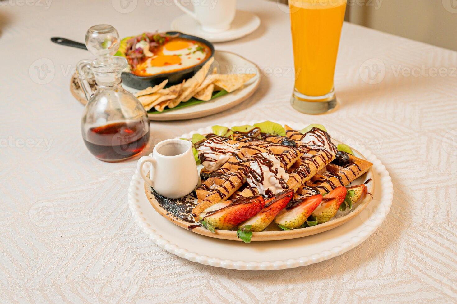 Fruit crepes with chocolate and maple syrup for breakfast photo