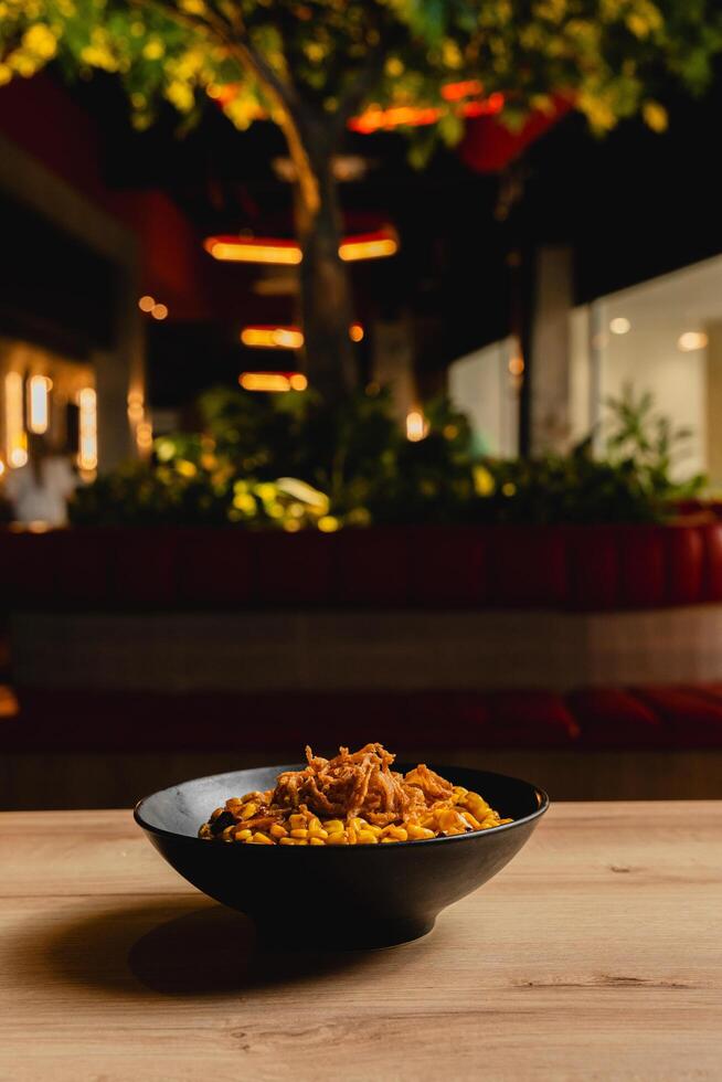 Colombian-style desgranado, featuring corn, chicken, beef, vegetables, shredded potato, French fries, and a variety of sauces. photo
