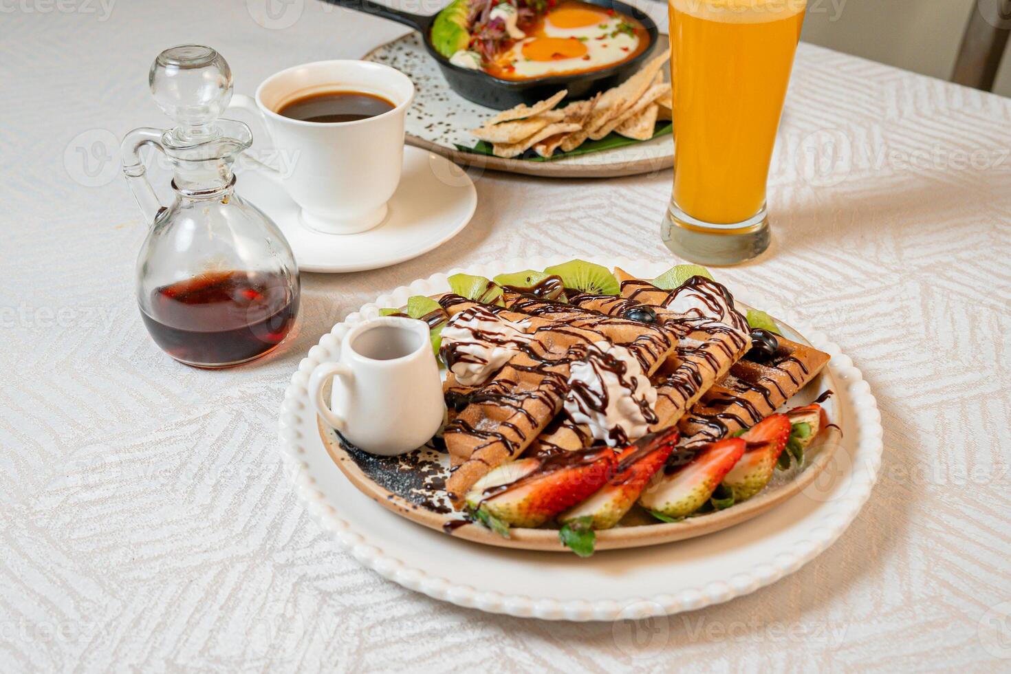 Fruit crepes with chocolate and maple syrup for breakfast photo