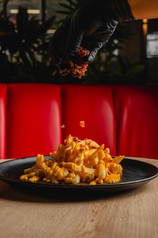 French fries topped with melted cheese and bacon bits. photo