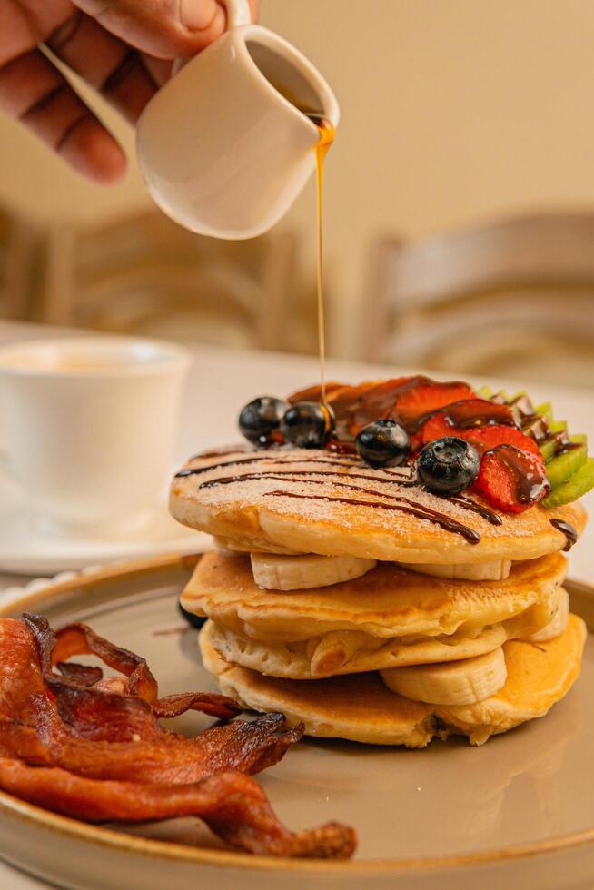 Fruit crepes with chocolate and maple syrup for breakfast photo