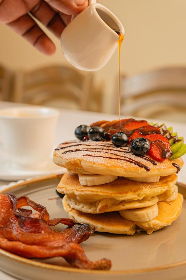 Fruit crepes with chocolate and maple syrup for breakfast photo