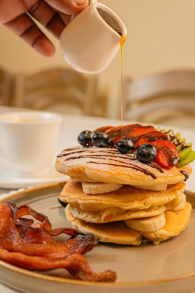 Fruit crepes with chocolate and maple syrup for breakfast photo