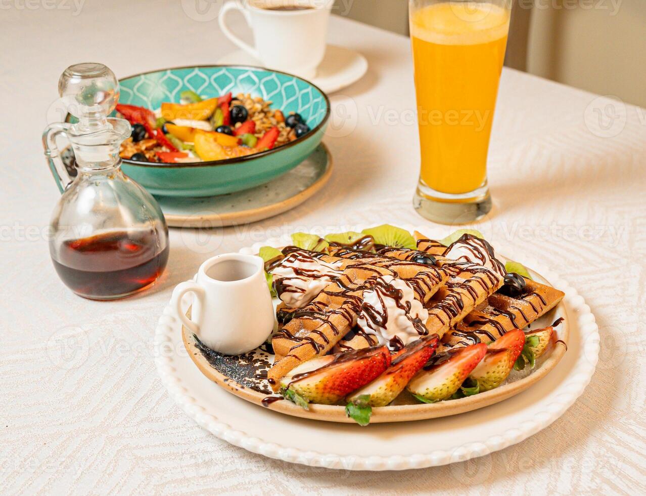Fruit crepes with chocolate and maple syrup for breakfast photo