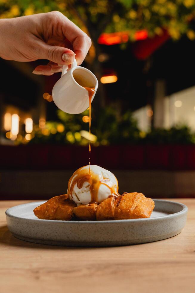 Cheese strudel with ice cream and caramel sauce drizzling on top. photo