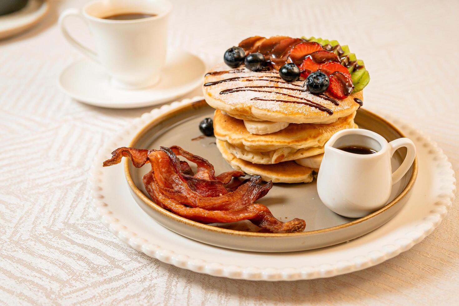 Fruit crepes with chocolate and maple syrup for breakfast photo