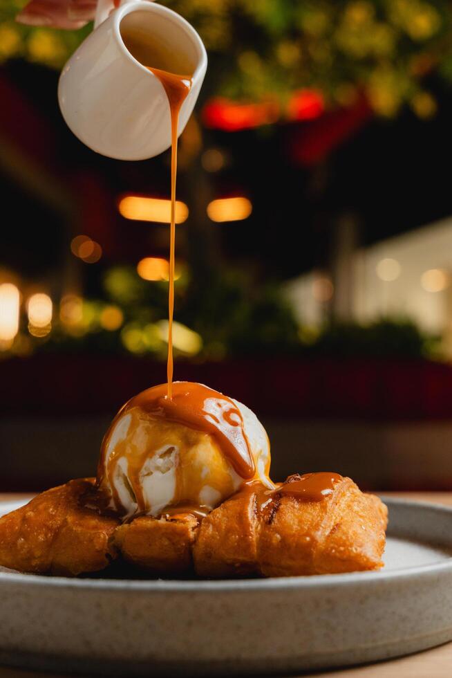 Cheese strudel with ice cream and caramel sauce drizzling on top. photo