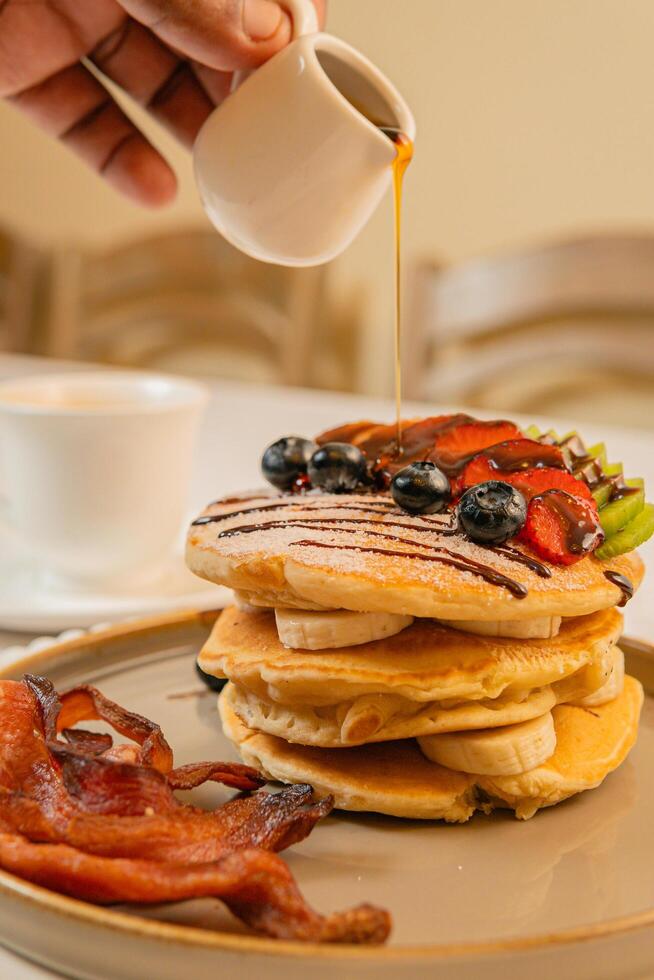 Fruit crepes with chocolate and maple syrup for breakfast photo