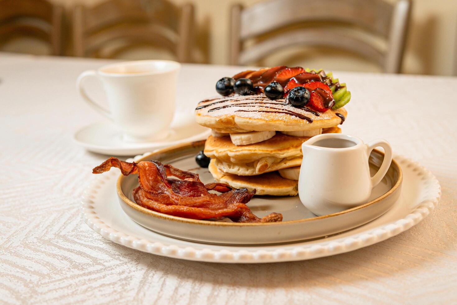 Fruit crepes with chocolate and maple syrup for breakfast photo